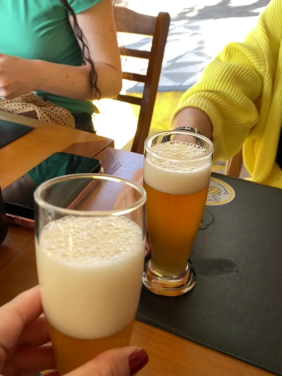 Dois copos de chope erguidos num brinde à mesa